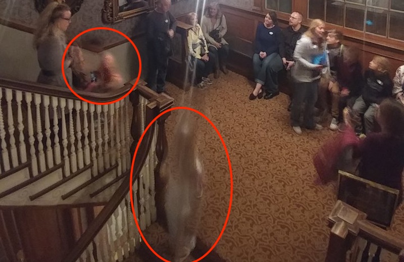 Stairwell at the Stanley Hotel with a group and two ghostly figures circled